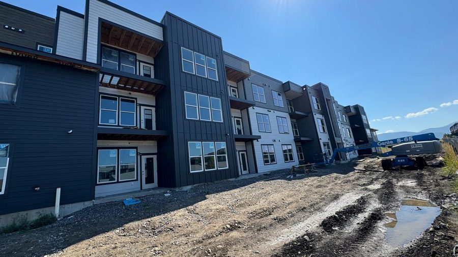 A row of apartment buildings with dark and light siding