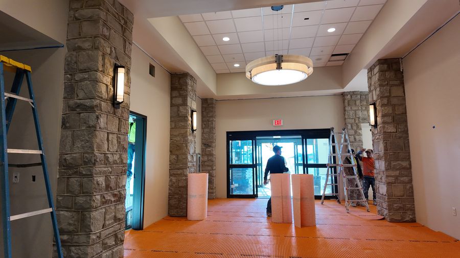A commercial lobby with stone columns and glass entry doors