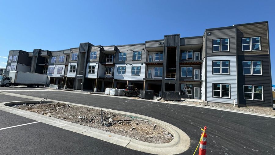 A three-storey apartment building with dark and white siding