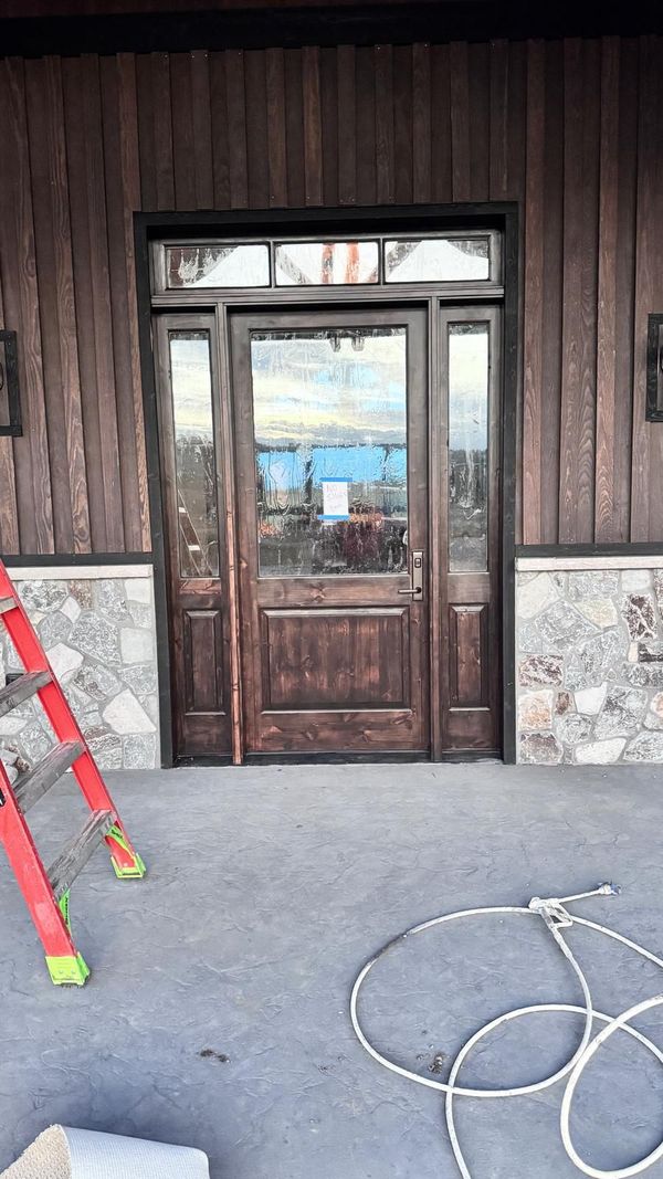 A dark stained entry door set in a stone surround