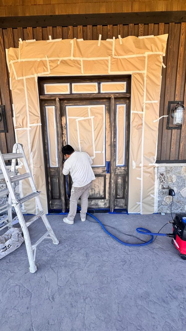 A masked and papered entry with a ladder set up