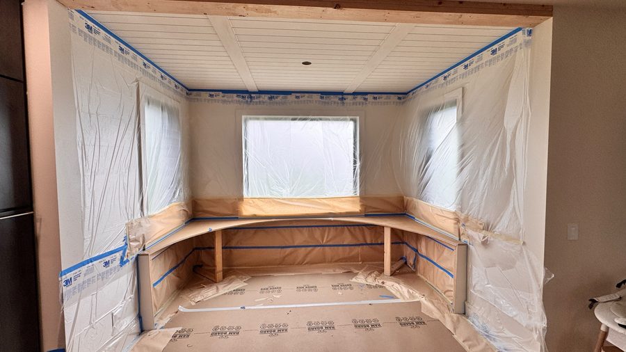 A bay window seat masked off before paint